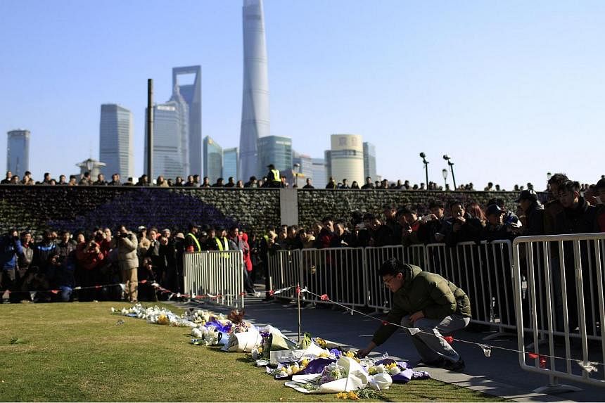 People laying down flowers during a memorial ceremony on Jan 1, 2015, in memory of people who were killed in a stampede incident during a New Year's celebration on the Bund, in Shanghai. -- PHOTO: REUTERS