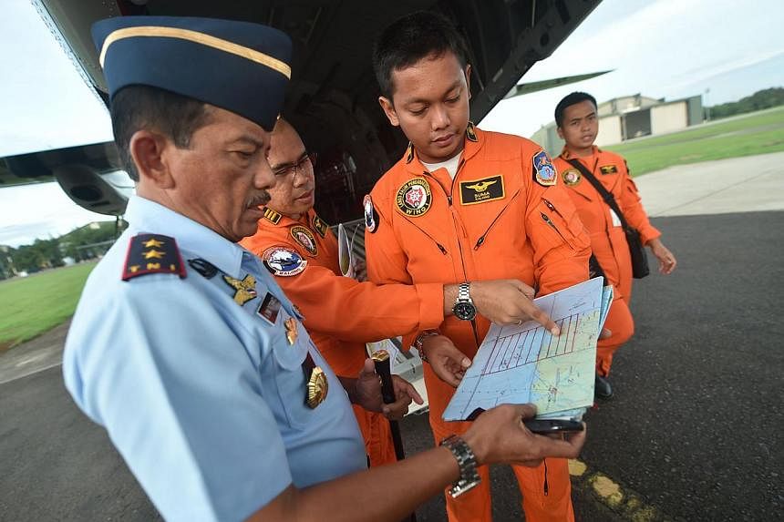 Western Indonesia Air Force operation commander Agus Dwi Putranto (left) briefs crew before a search and rescue operation for the missing AirAsia flight QZ8501, in Jakarta on Dec 30, 2014. -- PHOTO: AFP&nbsp;