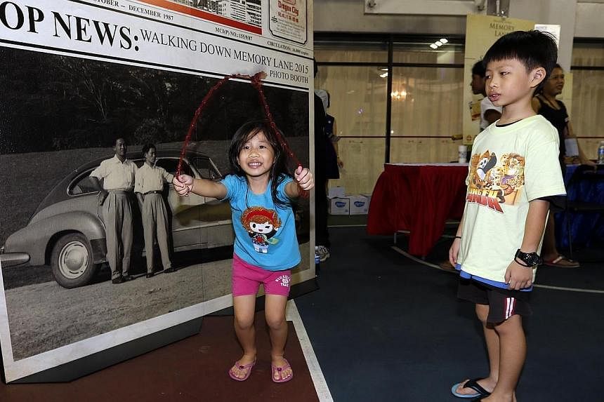 Joylene Teo (left), 5 and her brother Jovan Teo, 7&nbsp;attending the&nbsp;Walking Down Memory Lane 2015 exhibition at Jurong Green Community Club on Saturday, Jan 3, 2015.&nbsp;-- ST PHOTO: LAU FOOK KONG