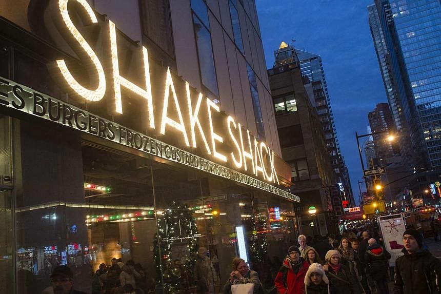 Passersby walk in front of the Shake Shack restaurant in the Manhattan borough of New York, on Dec 29, 2014. -- PHOTO: REUTERS