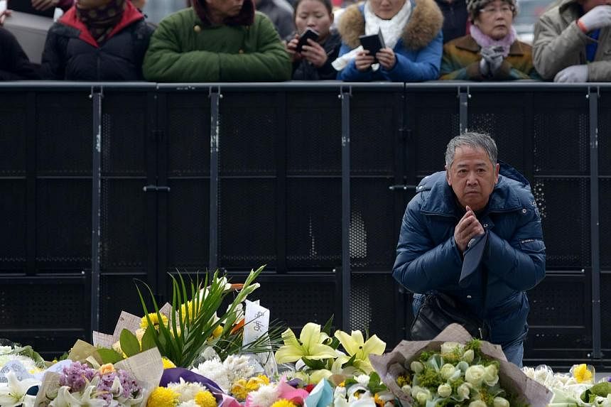 An elderly man prays for the victims at the site of the New Year's Eve stampede in Shanghai on Jan 3, 2015. -- PHOTO: AFP