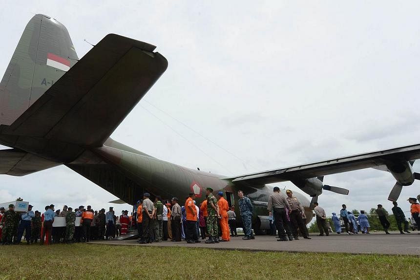 Indonesian officers carry coffins with the remains of passengers of AirAsia flight QZ8501 before being sent to Surabaya, in Pangkalan Bun on Jan 3, 2015. -- PHOTO: AFP
