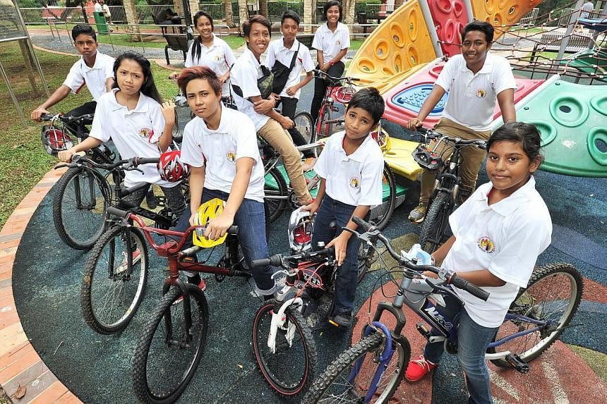 Ms Nur Elfizah Bte Rohaizat, (front row with yellow helmet) 19, one of the youth leaders in the Henderson Bikers' cycling club, with other members of the Henderson Bikers' cycling club on Jan 3, 2015. -- PHOTO:&nbsp;LIM YAOHUI FOR THE STRAITS TIMES