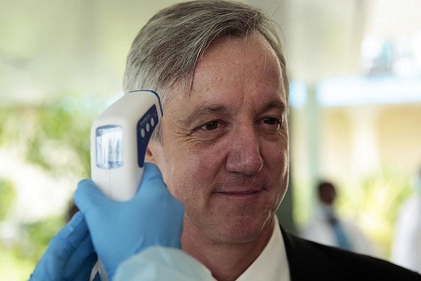 Outgoing Unmeer head Anthony Banbury getting his temperature measured during a visit to an Ebola medical unit on Dec 19, 2014. Mr Banbury said on Friday that the&nbsp;world can stamp out the Ebola outbreak in West Africa by the end of the year but mo