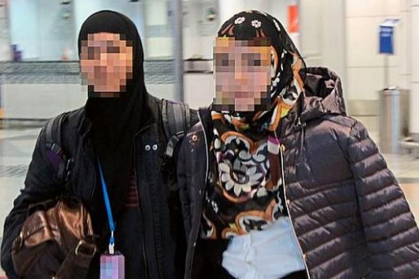 A woman officer (left) from the Bukit Aman Special Branch Counter-Terrorism Division is seen escorting the 27-year-old university dropout . -- PHOTO: THE STAR/ASIA NEWS NETWORK