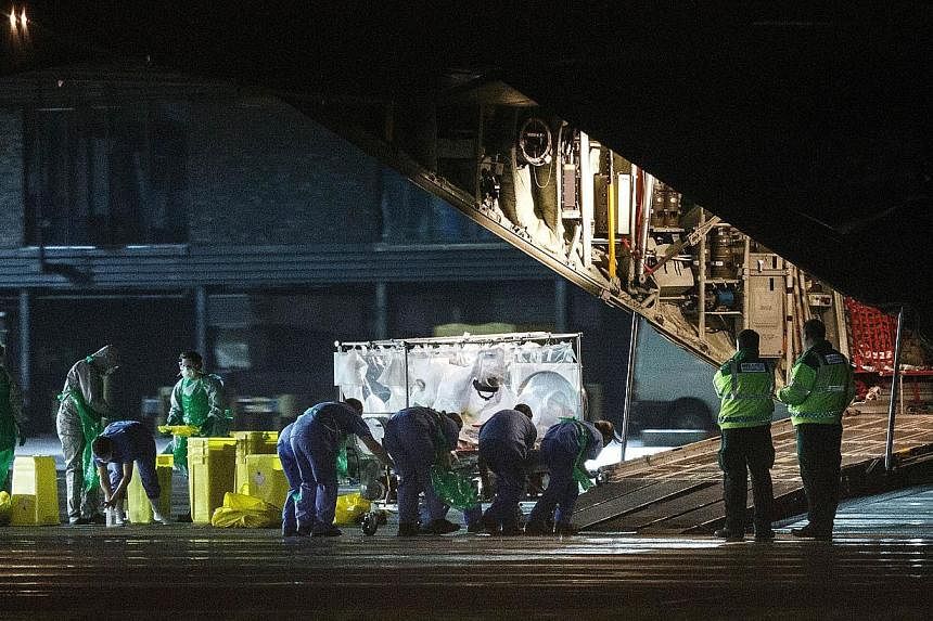 A British nurse&nbsp;who was diagnosed with Ebola after returning from Sierra Leone is wheeled in a quarantine tent trolley onto a Hercules Transport plane at Glasgow International Airport on Dec 30, 2014. -- PHOTO: AFP