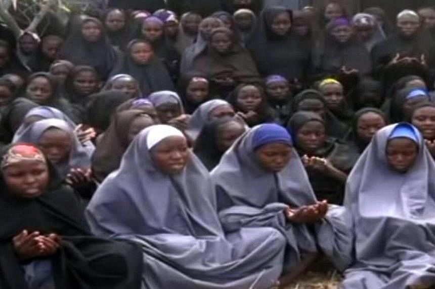A screen grab taken on May 12, 2014 from a video of Nigerian Islamist extremist group Boko Haram shows girls wearing the full-length hijab and praying in an undisclosed rural location. The parents of 200 Nigerian schoolgirls kidnapped by Islamist reb