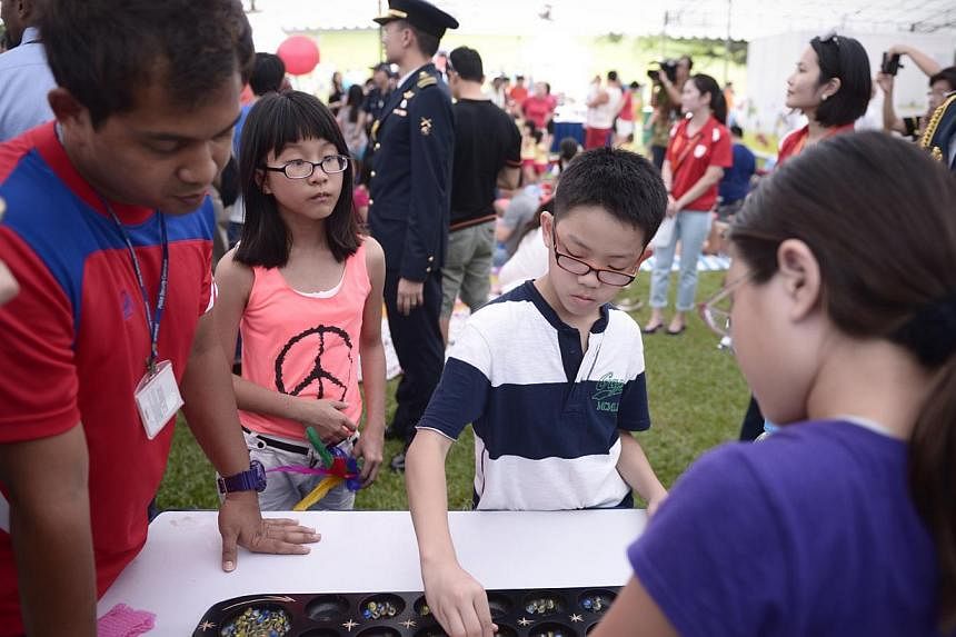 Kids play congkak at the first ever SG50 family picnic at the Istana. -- ST PHOTO:&nbsp;MARK CHEONG