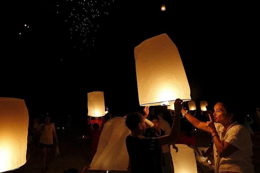 Police in Thailand will clamp down on the popular folk custom of flying paper lanterns, after a Chiang Mai-Bangkok flight had to be cancelled on New Year's Day due to a stray lantern ending up in the jet's engine. -- PHOTO: REUTERS