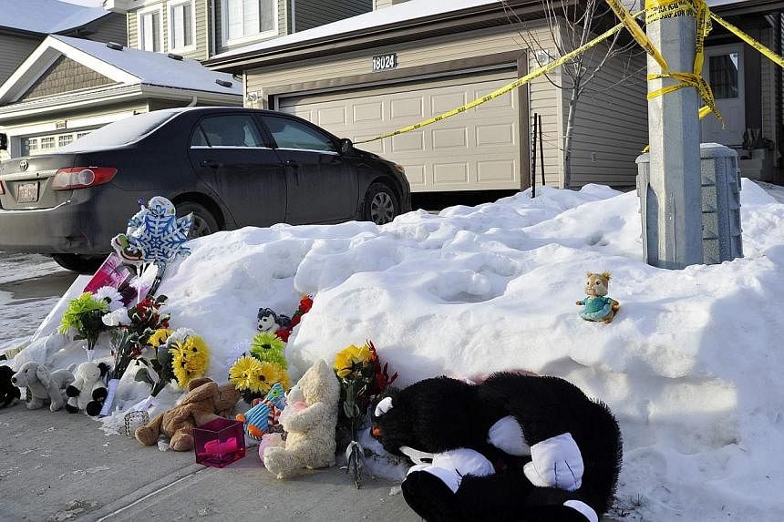 A makeshift memoria at the home where seven people were found dead in Edmonton, Alberta, on Dec 31, 2014. -- PHOTO: REUTERS