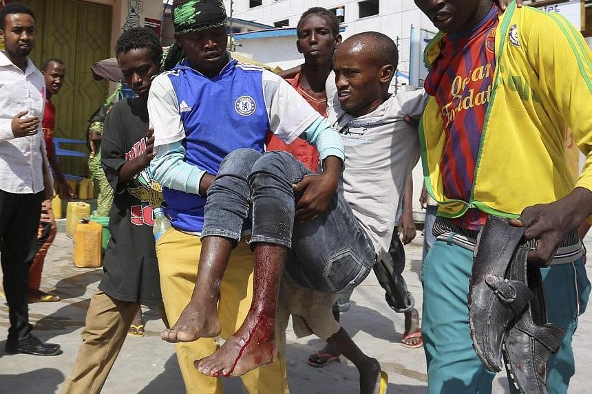 Residents evacuate a civilian injured in a car bomb explosion near Somalia's capital Mogadishu.-- PHOTO: REUTERS