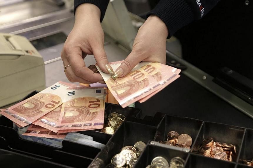 A cashier counts euro banknotes in a shop in Vilnius, Lithuania. The single currency tumbled to its lowest since early 2006 in Asia on Monday as a wave of stop-loss sales were tripped on the break of major chart support, sending the U.S. dollar flyin