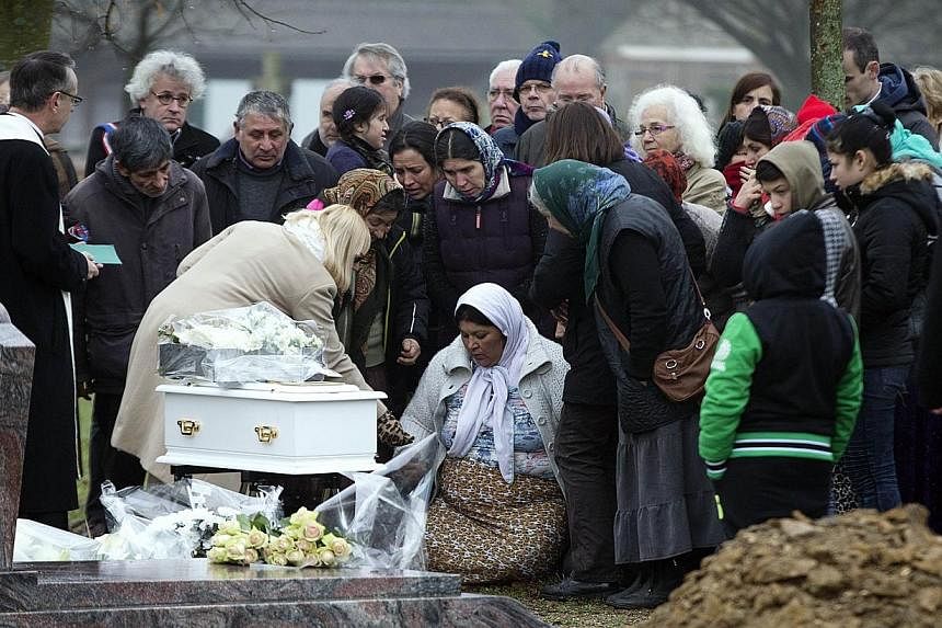The mother of the late Maria Francesca pays homage to her baby during her funeral on Jan 5, 2015 at the Wissous cemetery.&nbsp;The dead baby of a Roma family at the centre of a huge racism row in France was finally laid to rest on Monday with just cl