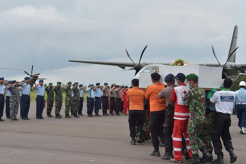 Indonesian officers carry a coffin with the remains of a passenger of the AirAsia flight QZ8501 in Pangkalan Bun on Jan 5, 2015.&nbsp;The airline will have to pay compensation to the next of kin of victims of the crashed flight, Indonesian officials 