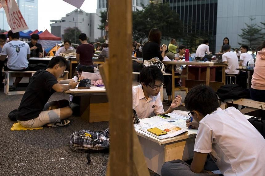 Occupy Central protesters sit at a study area along the main street to the financial Central district as they continue blocking areas outside of the government headquarters building in Hong Kong on Oct 20, 2014. -- PHOTO: REUTERS