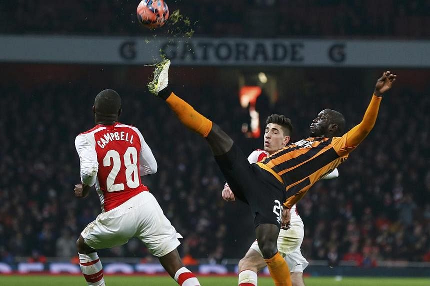Yannick Sagbo of Hull City stretches for the ball during their FA Cup third round soccer match against Arsenal at the Emirates Stadium in London on Sunday. -- PHOTO: REUTERS