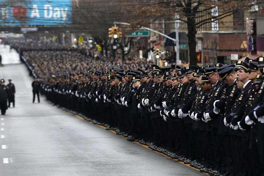 Police stand in formation down 65th street as they listen to the funeral service for New York Police Department officer Liu Wenjian&nbsp;in the Brooklyn borough of New York on Jan 4, 2015. -- PHOTO: AFP