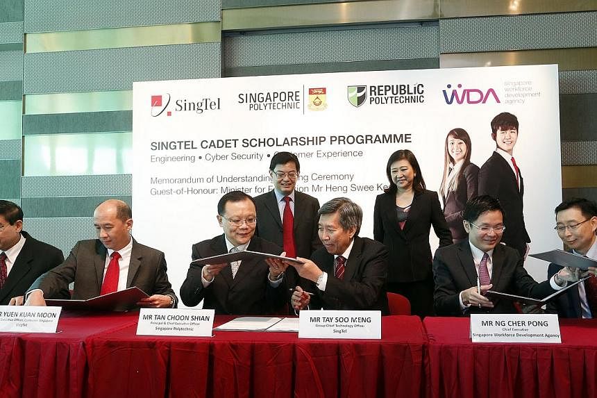 Minister for Education Heng Swee Keat (back row, left) witnesses the signing of an MOU for a new diploma scholarship programme launched by telco SingTel on Tuesday, and jointly developed with Singapore and Republic polytechnics. &nbsp;-- ST PHOTO: CH