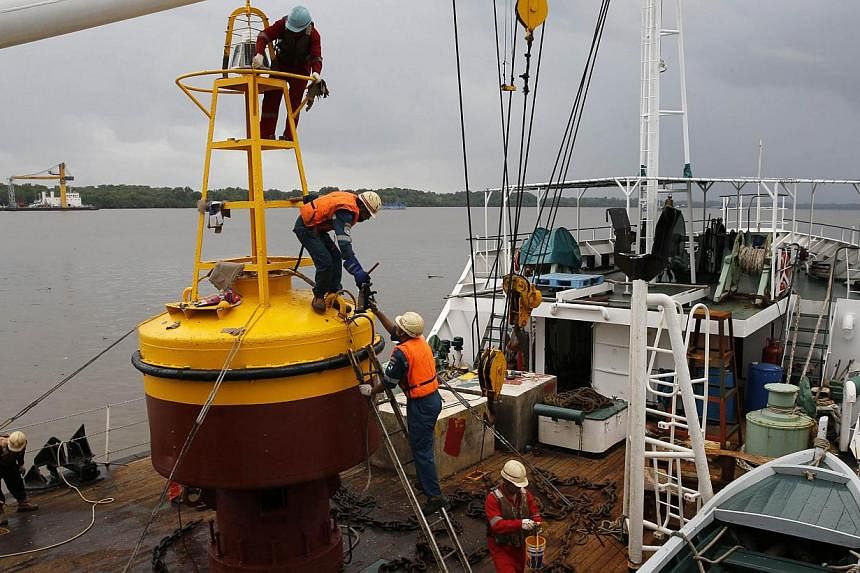 Workers assembling a beacon buoy that will be placed on the site where, according to officials, the tail of crashed AirAsia flight QZ8501 has been located, near Kumai port in Pangkalan Bun on Jan 5, 2015. -- PHOTO: REUTERS