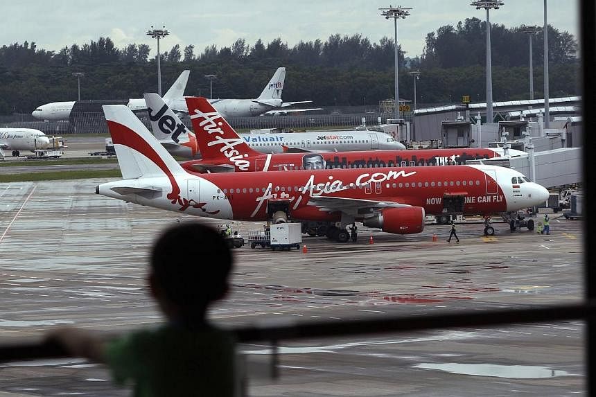 A child looks on at a viewing gallery overlooking AirAsia planes on the tarmac at Changi Airport in Singapore on Dec 29, 2014.&nbsp;Transportation Minister Ignasius Jonan should be held responsible an alleged illegal flight schedule involving budget 