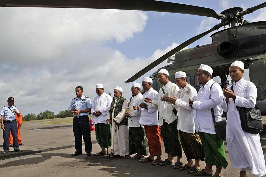 Muslim clerics praying before embarking on a flight with Indonesian Air Force NAS 332 Super Puma helicopter, to fly over the Java Sea to offer prayers for victims of AirAsia flight QZ 8501, at Iskandar Airport in Pangkalan Bun, on Jan 6, 2015. -- PHO