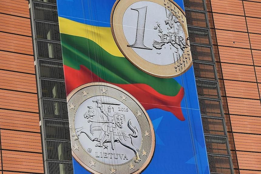 A detail of a banner welcoming Lithuania into the Eurozone hung on the European Commission headquarters in Brussels on Jan 5, 2015. The euro wallowed near a nine-year trough early on Tuesday as the prospect of more policy easing from the European Cen