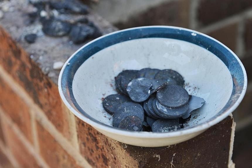 Melted coins lay fused together in the destroyed remains of a home after a bushfire moved through the area near Kersbrook in the Adelaide Hills on Jan 5, 2015. -- PHOTO: AFP