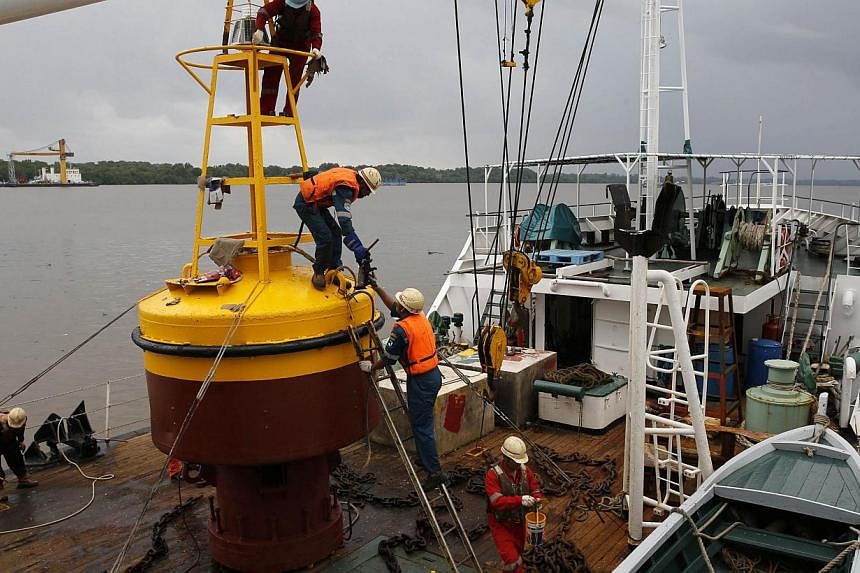 Workers assemble a beacon buoy that will placed on the site where, according to officials, the tail of crashed AirAsia flight QZ8501 has been located, near Kumai port in Pangkalan Bun on Jan 5, 2015. -- PHOTO: REUTERS