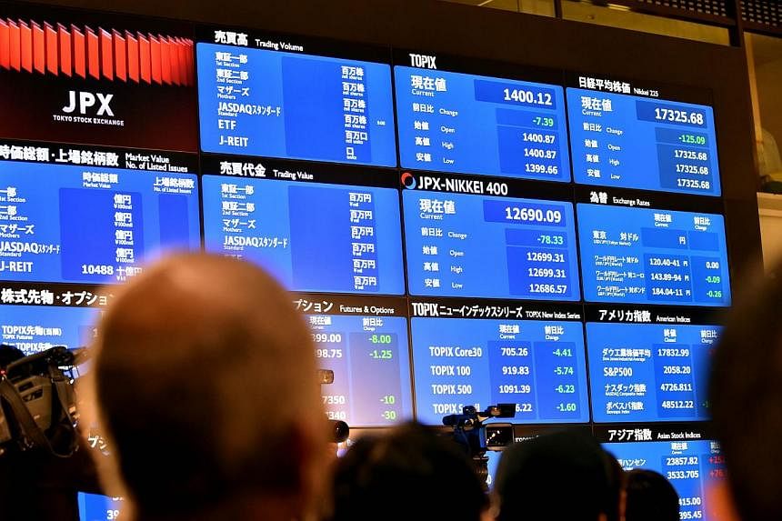 Visitors look at a board displaying the opening trade of the first trading day of the year at the Tokyo Stock Exchange on Jan 5, 2015. Asian shares tumbled on Jan 6 as sliding oil prices and political uncertainty in Greece forced investors out of ris