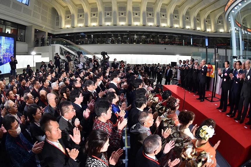 Executives of the Japan Exchange Group and visitors celebrating the first trading day of the year during the opening ceremony at the Tokyo Stock Exchange on Jan 5, 2015. Tokyo stocks opened 1.76 per cent lower on Tuesday following a slump in US share
