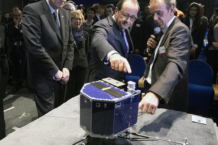 National Centre for Space Studies (CNES) president Jean-Yves Le Gall (left), French President Francois Hollande and French astrophysicist Francis Rocard looking at a model of Rosetta lander Philae during a broadcast of the Rosetta mission on the 67P/
