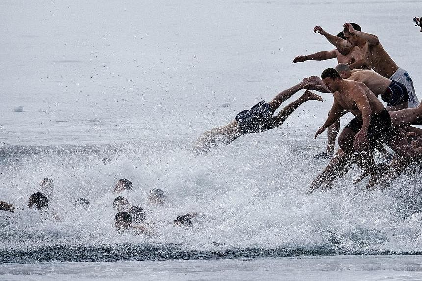 Bulgarians dive into the icy waters of a lake to catch a cross in Sofia as part of Epiphany Day celebrations on Tuesday. It is believed that the first man to grab the cross, thrown into the water by an Eastern Orthodox priest, will be healthy through