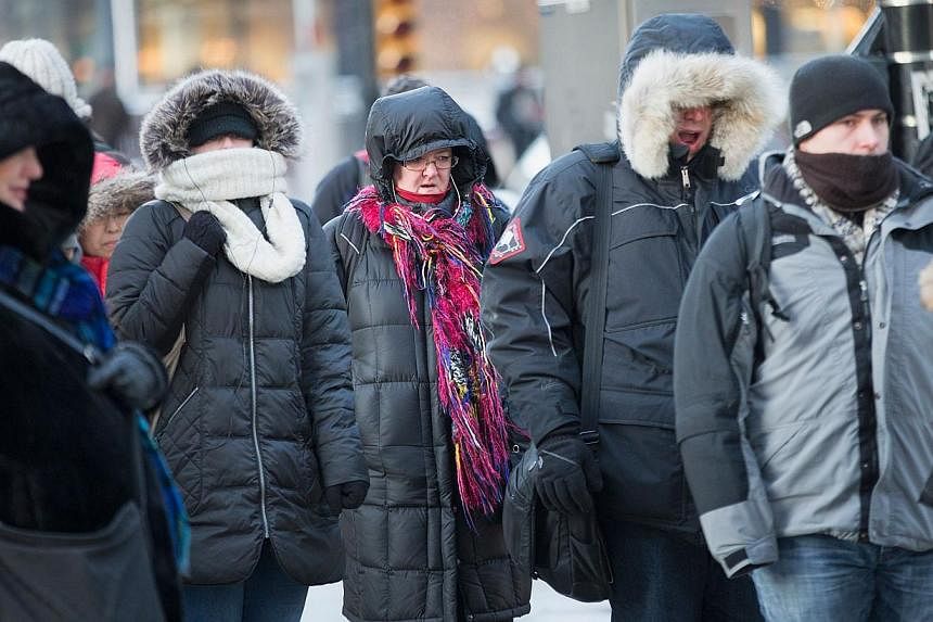 Commuters make their way to work as temperatures hovered around -20 degrees C during the morning rush on Monday in Chicago, Illinois. Temperatures are expected to remain well below zero today and the rest of the week with snow squalls. -- PHOTO: AFP