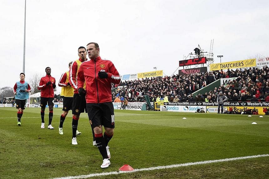 Manchester United players warm up ahead of their FA Cup third round soccer match on Sunday. -- PHOTO: REUTERS