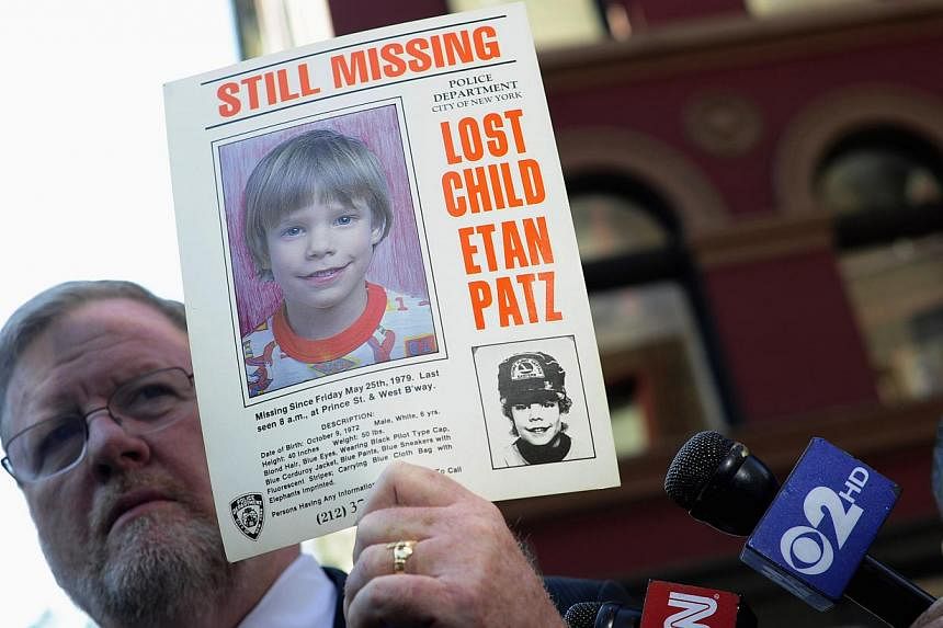 New York Police Department spokesman Paul Brown holding an original missing poster of Etan Patz during a news conference near a New York City apartment building, where police and FBI agents were searching a basement for clues in the boy's 1979 disapp