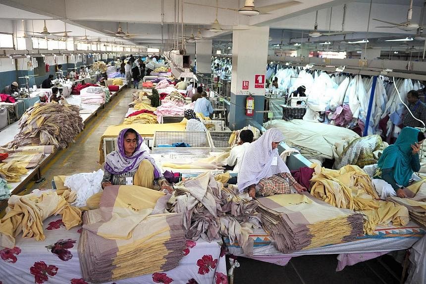 Pakistani employees working in a textile factory in Karachi on Nov 11, 2014,. More than two years after a fire tore through a Karachi clothing factory, killing 255 workers, no one has been prosecuted over the catastrophe. -- PHOTO: AFP