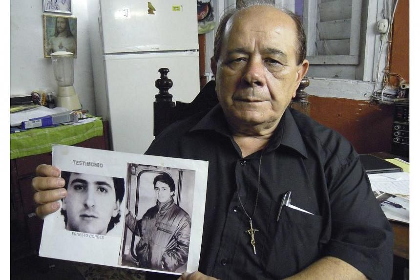 Mr Raul Borges, 74, holds a picture of his son, Ernesto Borges, in his house in Havana, Cuba, on Jan 2, 2015. Ernesto Borges, a KGB-trained counter-intelligence officer, has been in a Cuban prison for 16 years for attempting to hand over secrets to a