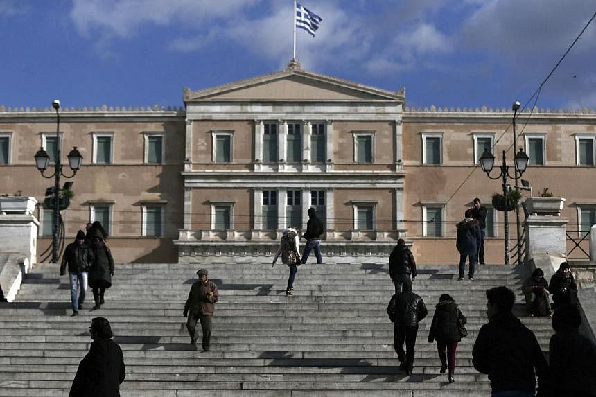 People making their way in central Syntagma Square with the parliament building in the background in Athens on Jan 6, 2015. Germany and France are taking a coordinated and calculated risk in the hope of averting a leftist victory in Greece's general 
