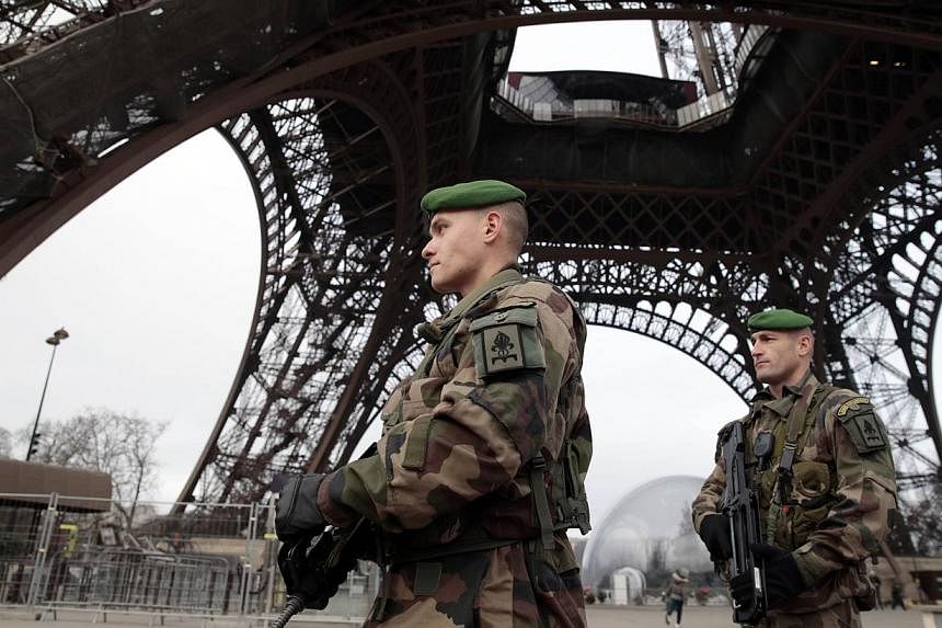French soldiers patrol in front of the Eiffel Tower on Jan 7, 2015, in Paris as the capital was placed under the highest alert status after heavily armed gunmen shouting Islamist slogans stormed French satirical newspaper Charlie Hebdo and shot dead 
