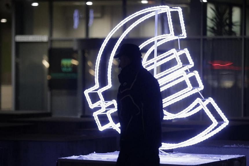 A euro sign light installation in Vilnius, the capital of Lithuania, on Dec 31, 2014. Lithuania adopted the euro currency on Jan 1, 2015. -- PHOTO: REUTERS
