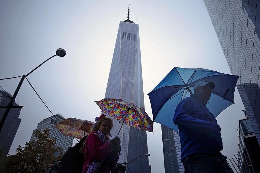 People walking next to the One World Trade Center in New York Nov 1, 2014. &nbsp;New York City regained its top position among global commercial real estate buyers, unseating London and highlighting the appeal of US properties in general, according t