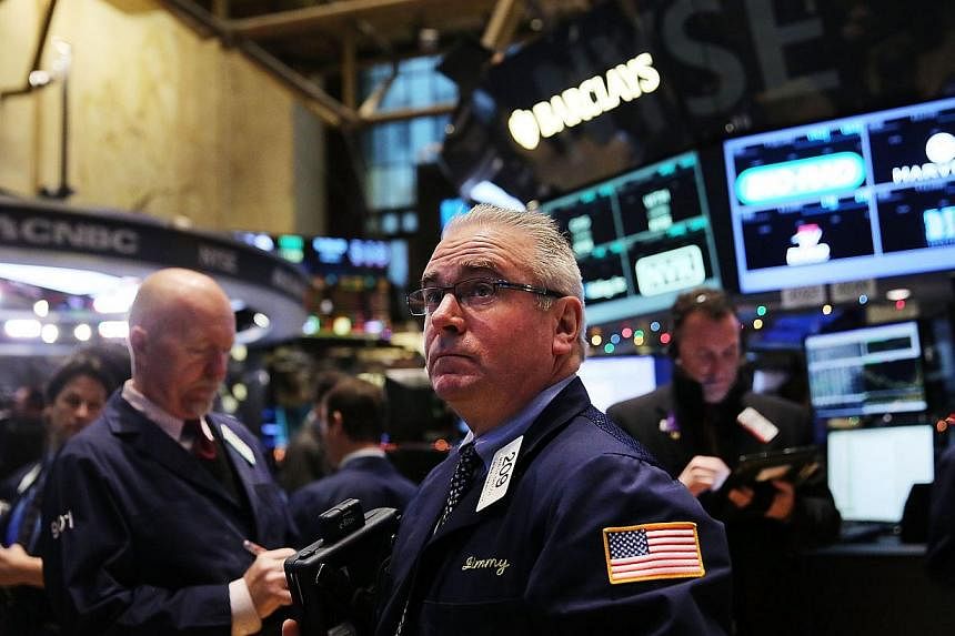 Traders working on the floor of the New York Stock Exchange (NYSE) on Tuesday in New York City. Stocks sank again, partly on fears of a continued fall in global oil prices. -- PHOTO: AFP&nbsp;