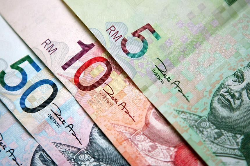 The Malaysian ringgit fell to fresh historic lows upon news that crude oil prices had broken below the psychologically significant US$50 threshold. -- PHOTO:&nbsp;BLOOMBERG