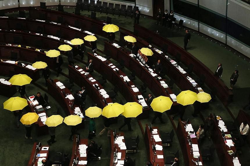 Pro-democracy lawmakers carrying yellow umbrellas, symbols for the Occupy Central movement, leave in the middle of a Legislative Council meeting as a gesture to boycott the government in Hong Kong Jan 7, 2015. -- PHOTO: REUTERS