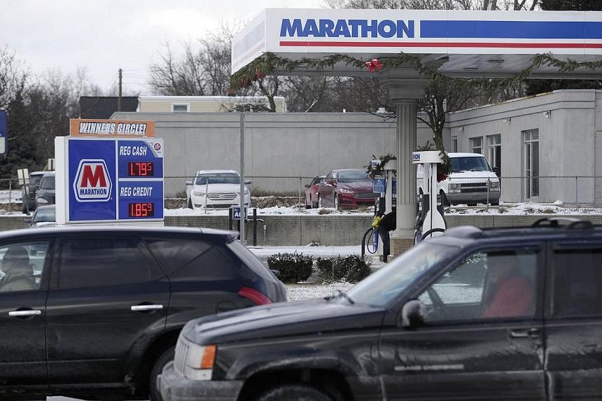 A Marathon petrol station on Jan 6, 2015 in Livonia, Michigan. US crude held above US$48 on Thursday after a surprise drop in inventories. -- PHOTO: AFP