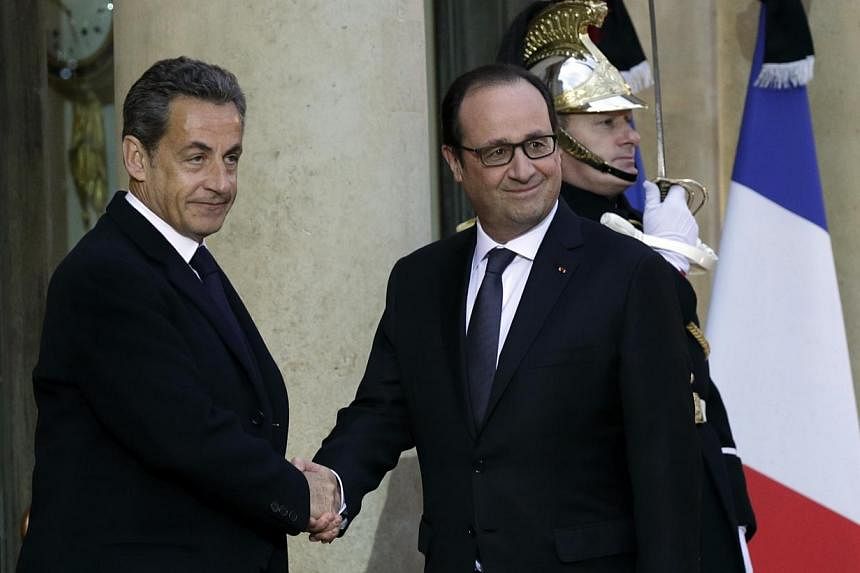 French President Francois Hollande (right) shakes hands with former French President Nicolas Sarkozy, head of the French conservative party UMP party, prior to a meeting at the Elysee Palace in Paris, on Jan 8, 2015, the day after a shooting at the P