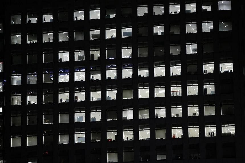 Office lights are seen through the windows of a high-rise office building in Tokyo on July 31, 2014.&nbsp;Japan's government is set to ensure all salaried employees go on paid annual leave by making it the responsibility of their employers, the Yomiu
