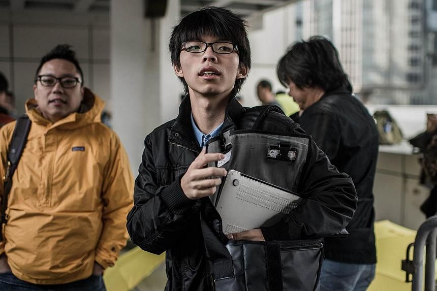 Hong Kong student activist Joshua Wong (centre) pictured outside the High Court in Hong Kong on Jan 8, 2015. -- PHOTO: AFP
