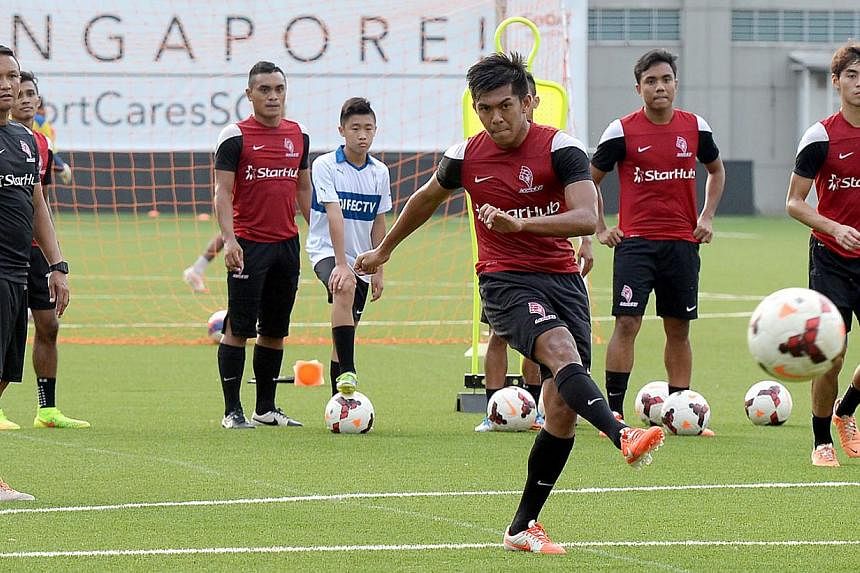 LionsXII striker Khairul Amri taking a shot during a training session with coach Fandi Ahmad (left) and his teammates looking on. With less than a month before the new Malaysia Super League (MSL) season kicks off, the LionsXII are embarking on their 