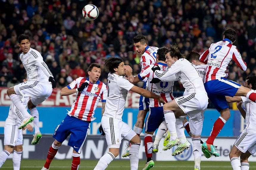 Atletico Madrid's Uruguayan defender Jose Gimenez (centre) heading to score during the Spanish Copa del Rey round of 16 first leg football match against Real Madrid at the Vicente Caldero on Jan 7, 2015. -- PHOTO: AFP